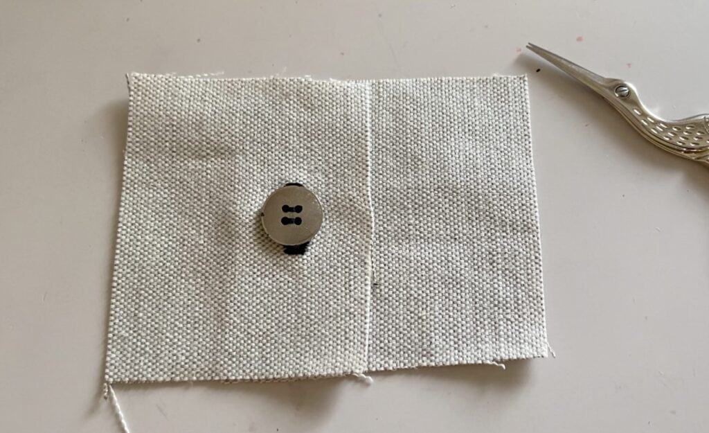 Bouton quatre trous inséré dans une boutonnière.