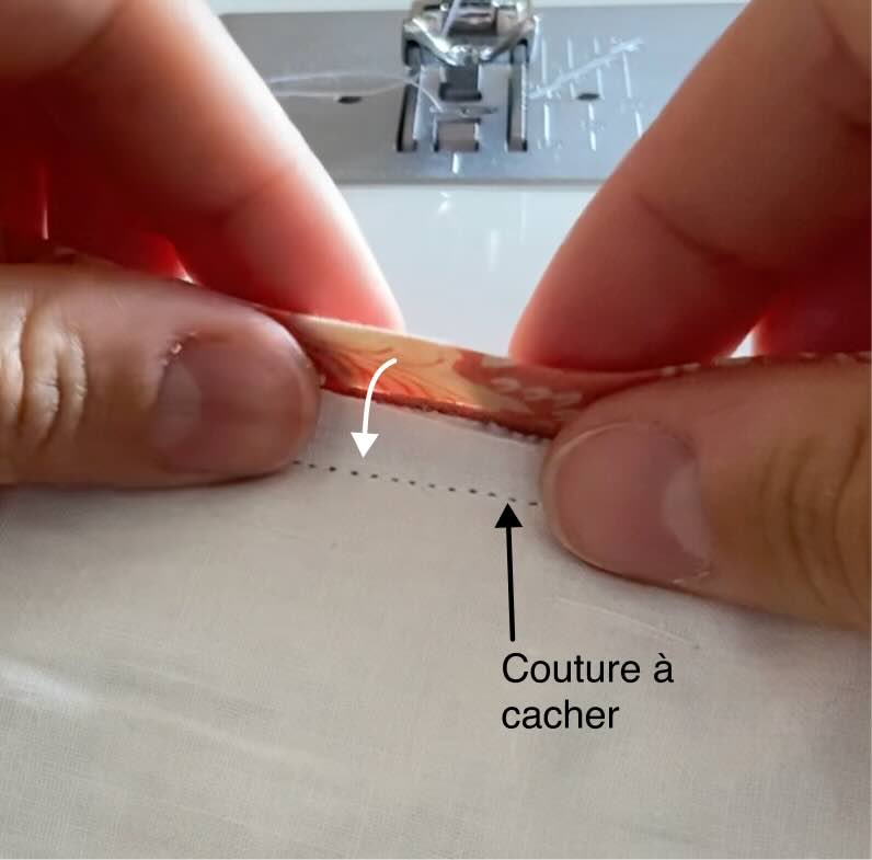 Une couturière repli le biais sur l'envers de la couverture.