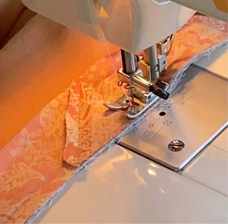 Une couturière continue de coudre le biais à la couverture.