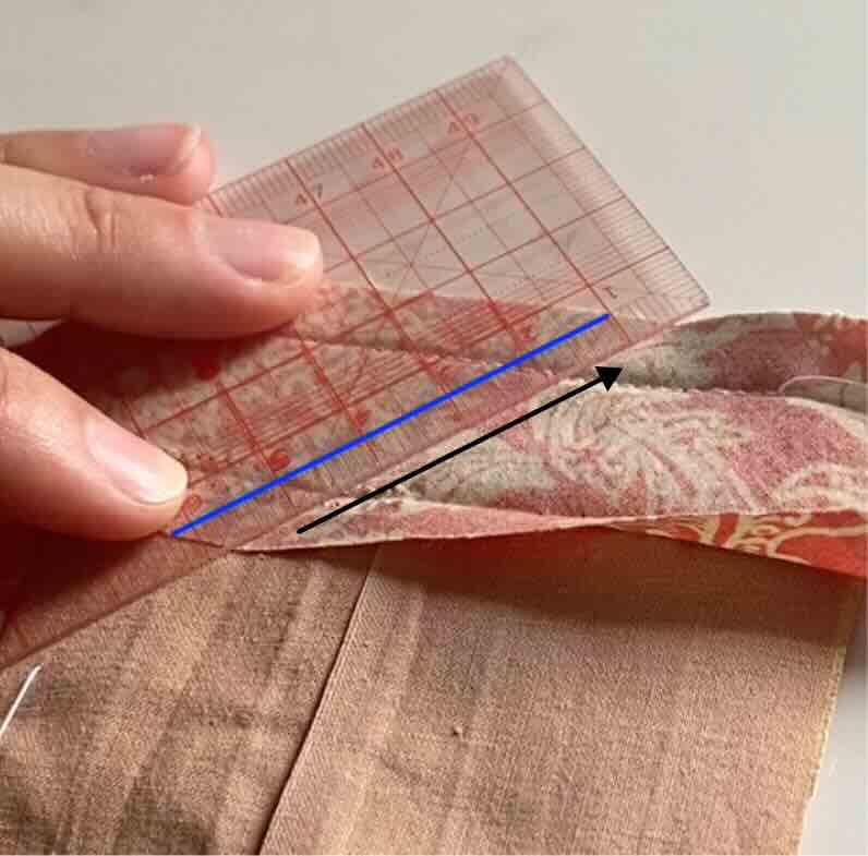 La ligne de coupe est tracée à 5mm à droite de la ligne de couture sur le biais.